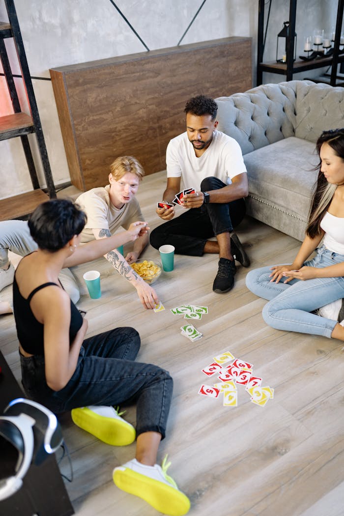 Group of young friends playing UNO together in a cozy indoor setting.